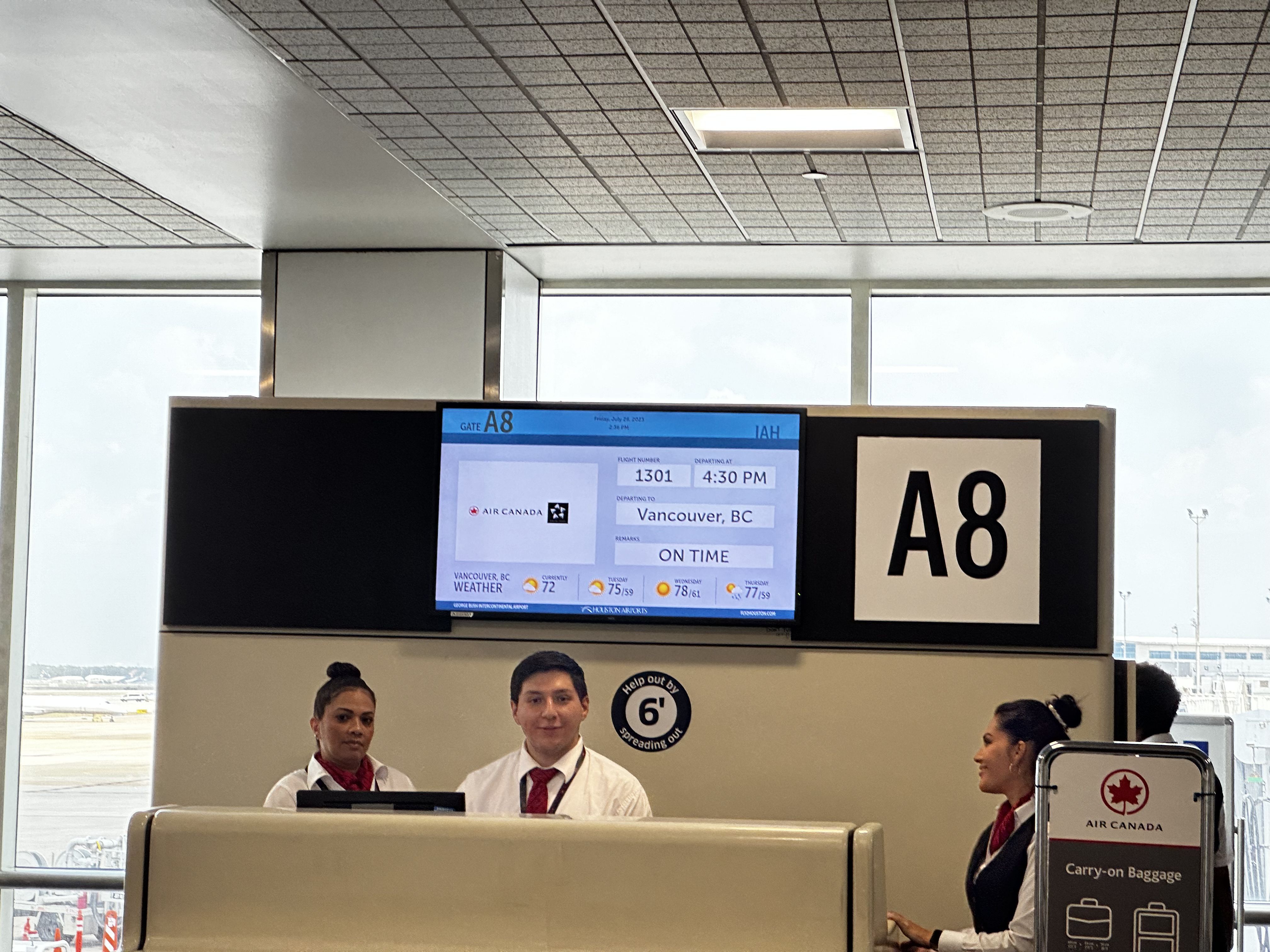 The departure screen at gate A8 showing the flight leaving on time, with the gate agent seeming surprised to be photographed
