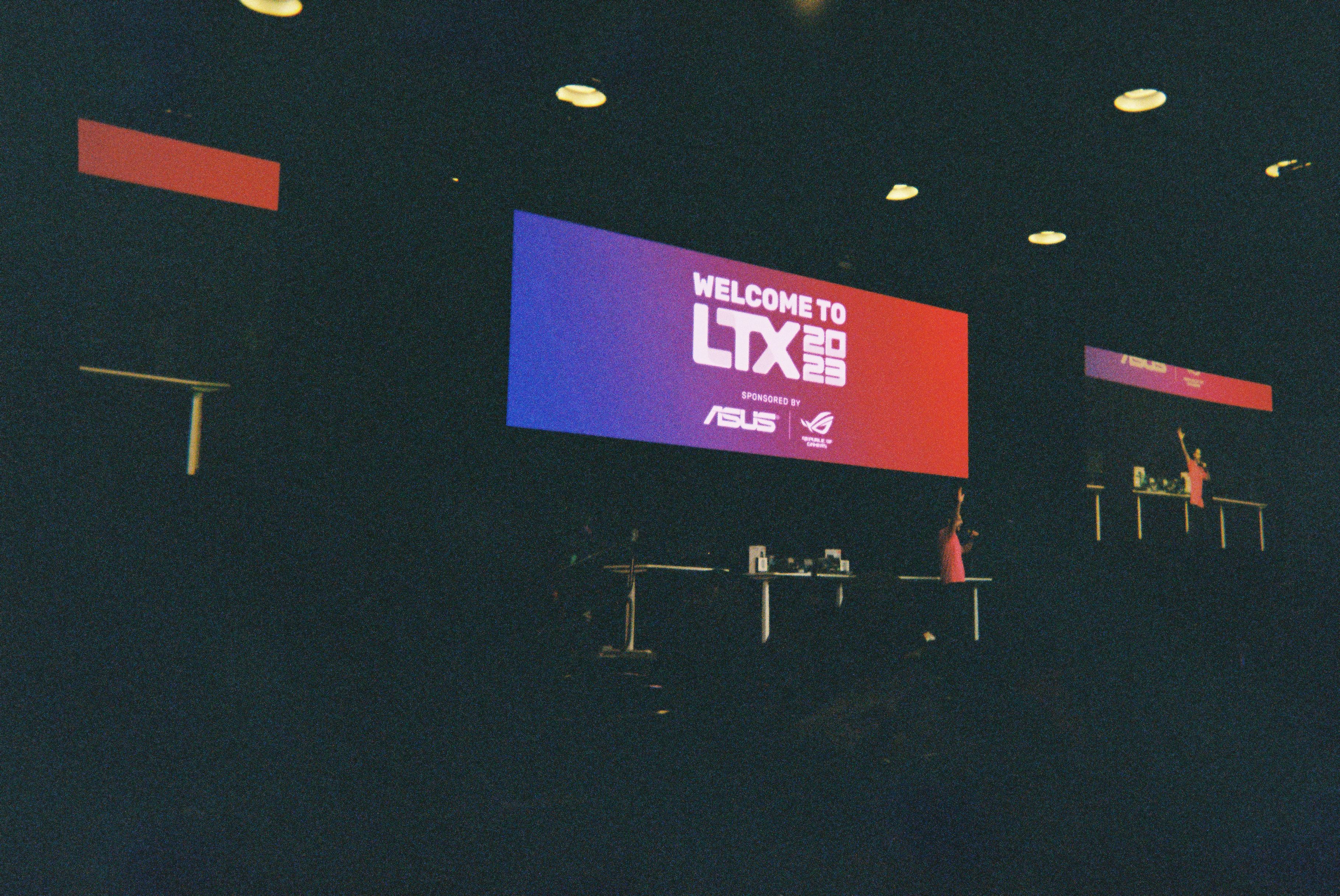 A projection screen saying "Welcome to LTX 2023!", with James from LTT firing up the crowd