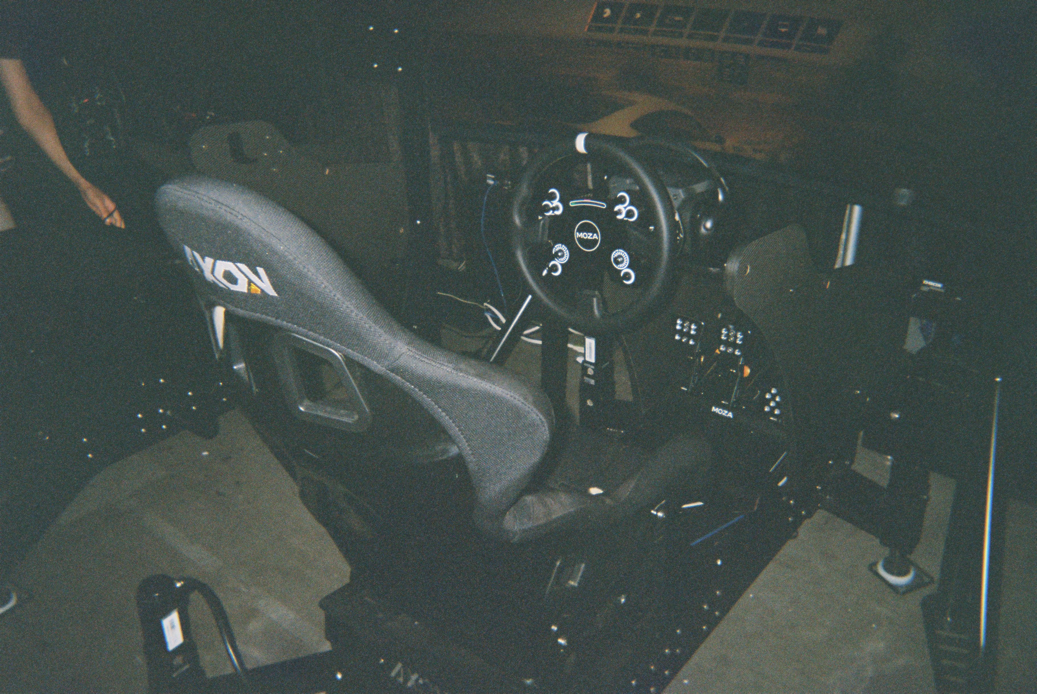 A full motion racing sim setup, complete with seat, wheel, pedals, and frame