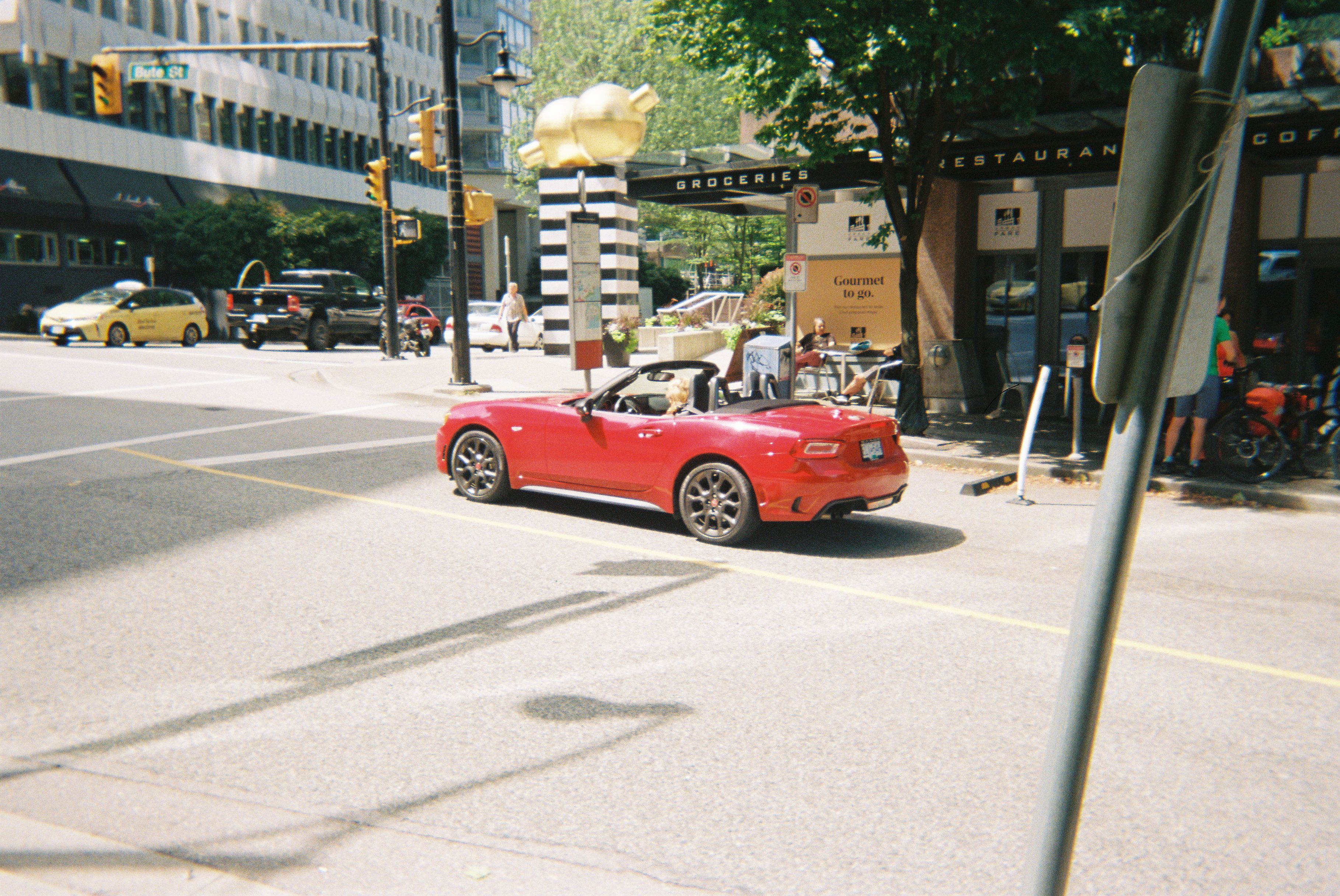 A Fiat 124 Spider driving down the street in Vancouver, BC